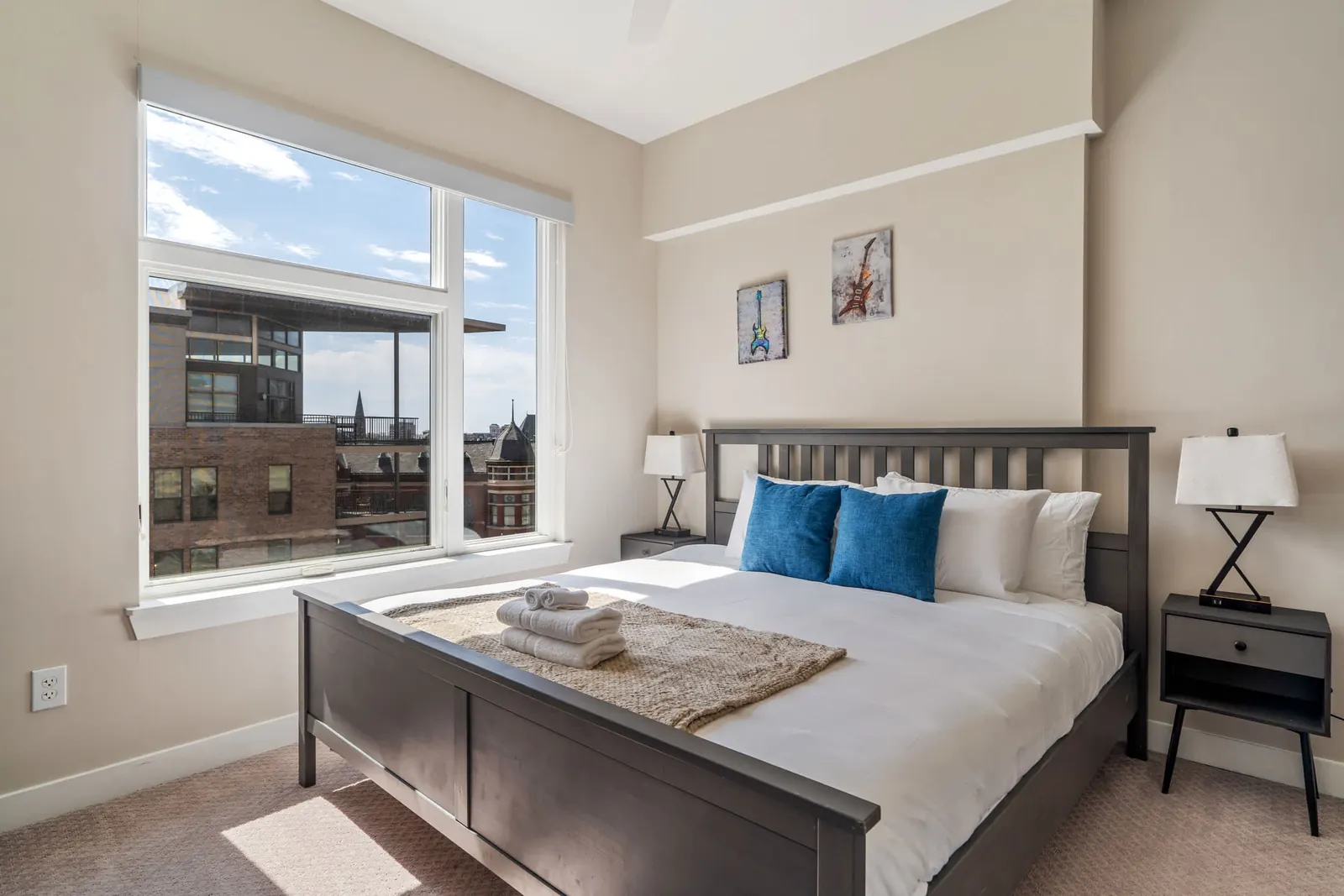Bedroom with a large window looking onto the city in a Roadmap Lodging home in Indianapolis