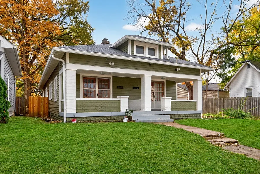 Exterior of a green craftsman house with a covered front porch, a Roadmap Lodging home in Indianapolis