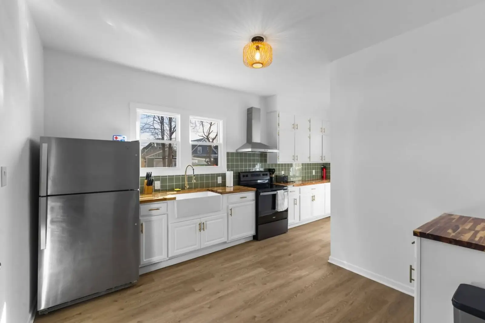 Kitchen with a farmhouse sink, range and full size refrigerator in a Roadmap Lodging home in Indianapolis