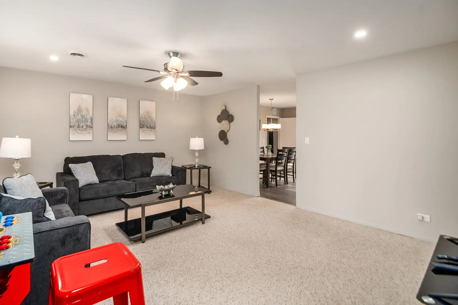 Living room with a sectional sofa opening onto a dining area, in a Roadmap Lodging home in Orland Park, Illinois